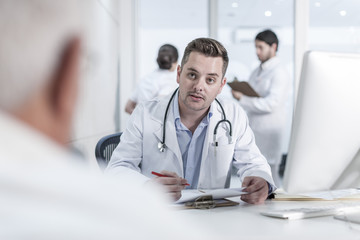 Doctor helping patient at clinic reception