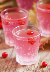 Pink cocktail with viburnum, cranberry and mountain ash on an au