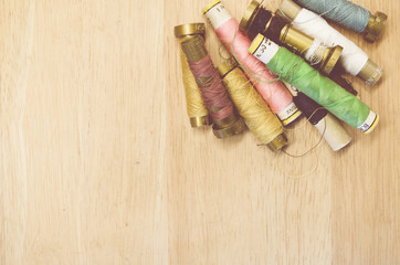 old sewing thread spools on wood background