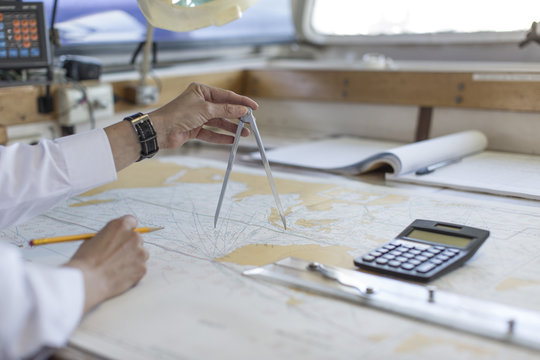 Deck officer working on a nautical map