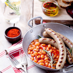 Grilled sausages with beans in tomato sauce