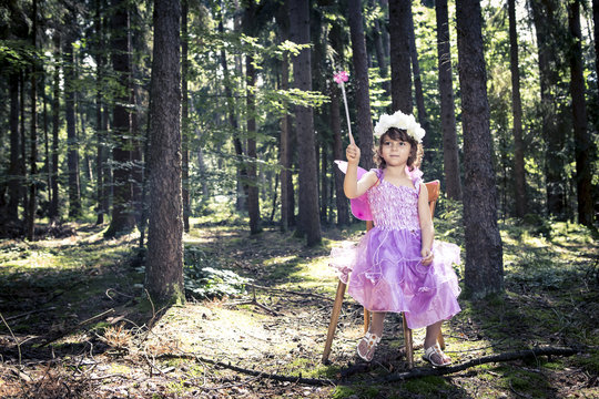 Little girl dressed as a fairy in the woods