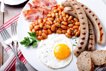 Fried egg with beans, bacon and grilled sausages