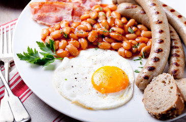 Fried egg with beans, bacon and grilled sausages