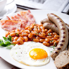 Fried egg with beans, bacon and grilled sausages