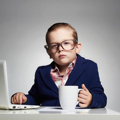 Young business boy. funny child in glasses. little boss in office