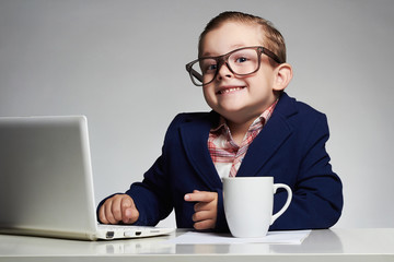 funny child with computer.Young business boy. smiling kid