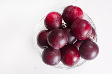Juicy cherry-plums in a glass bowl
