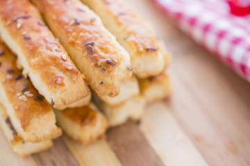 Bread Salty Grissini Sticks with sesame and flax seeds prepared for New Year's Day with red ribbon and red Christmas decorations