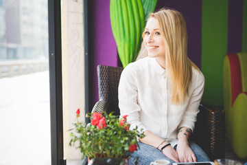 young beautiful blonde straight hair woman in the city sitting a