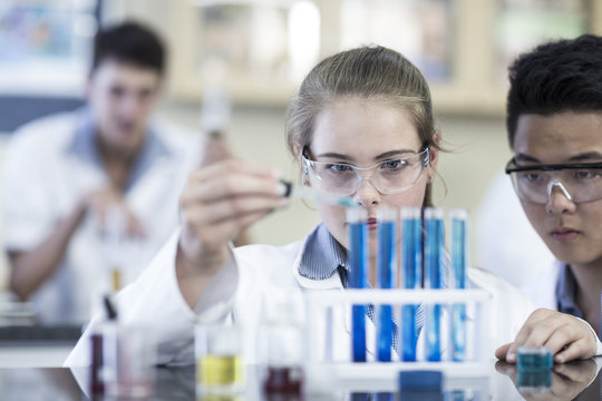 Students in chemistry class pipetting liquid into test tube