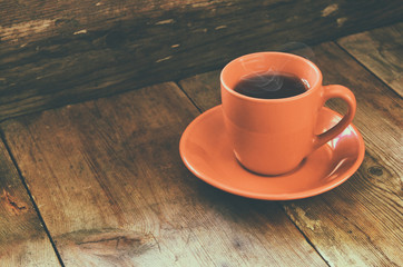 red cup of tea on wooden old table. retro filtered image
