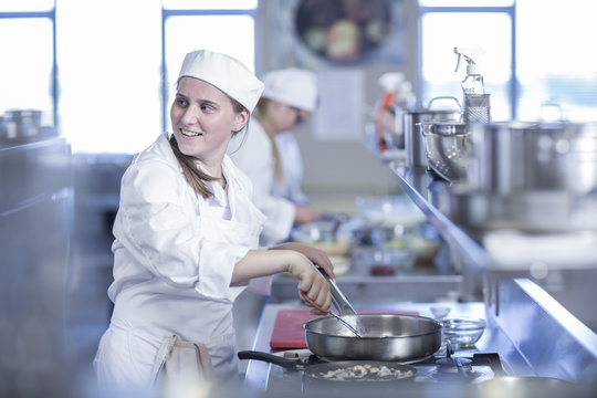 Teenage girl cooking in canteen kitchen