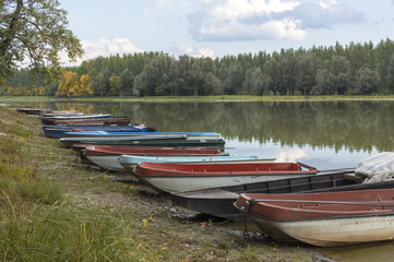 A group of boats on the beach by the lake in the autumn.