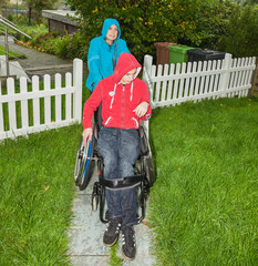 Mother with handicapped son in the rain