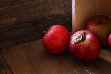 low key image of red apples over wodden textured table
