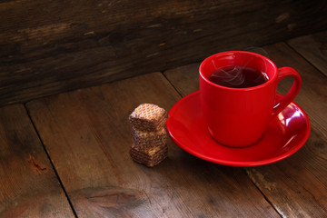 Cup of tea with waffle on wooden table
