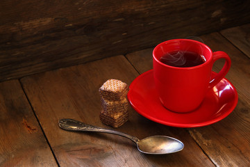 Cup of tea with waffle on wooden table
