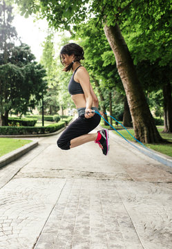 Spain, Oviedo, young woman jumping rope in the park