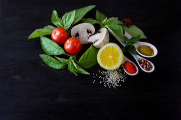 vegetables and spices on a black wooden background