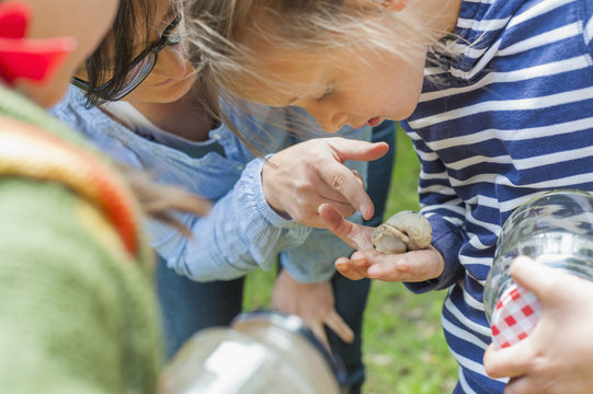 Germany, Children looking at snails