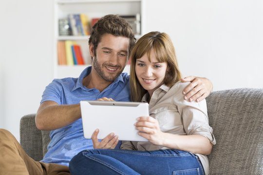 Young couple consulted their next trip on app tablet pc at home