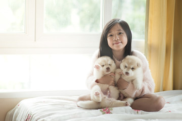 Little asian playing with siberian husky puppies