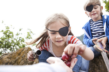 Boy and girl dressed up as pirates receiving cherries