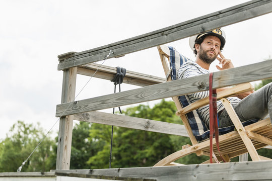 Man wearing captain's hat relaxing on  terrace