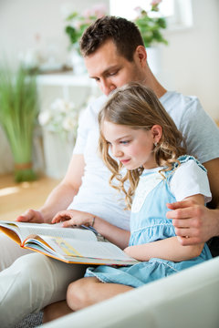 Father and daughter reading book
