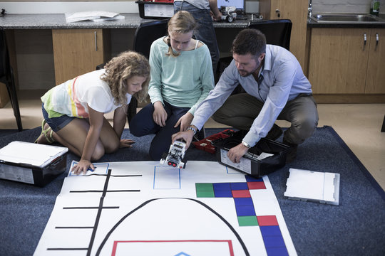 Teacher with schoolgirls on test track in robotics class