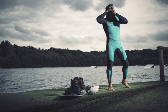 Young wakeboarder preparing at lakeshore