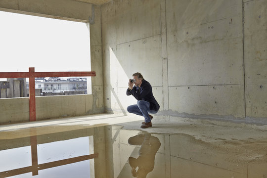 Man taking picture on construction site in unfinished building