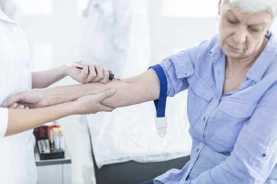 Nurse taking blood from patient, close up