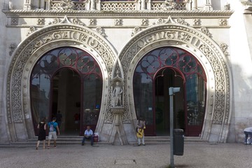 Architectural close up of Rossio Station entrance gateway in Lisbon, Portugal, with people.