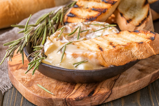 Homemade baked camembert with toasted bread and rosemary.