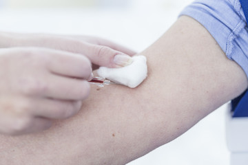 Nurse taking blood from patient, close up