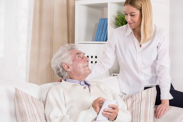 Obraz premium Helpful granddaughter visiting her grandfather