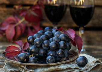 Black table grapes on plate with black wine