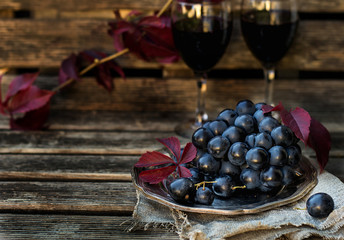 Black table grapes on plate with black wine