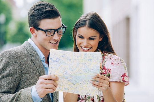 Smiling young couple reading map