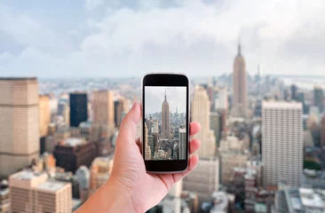 Tableaux ronds sur plexiglas Anti-reflet New York Main avec smartphone a pris des photos des toits de la ville de new york