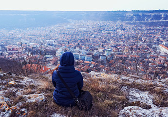 Young woman in a coat sitting