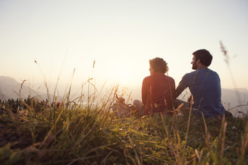 Austria, Tyrol, Unterberghorn, two hikers resting in alpine landscape at sunset