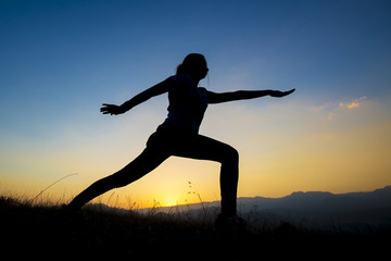 silhouette of young women who exercise at sunset