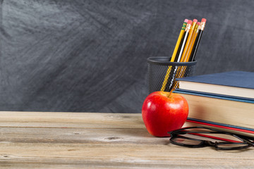 Old wooden desktop with reading materials and blackboard for back to school concept 