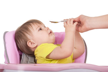 Mom spoon feeds baby girl
