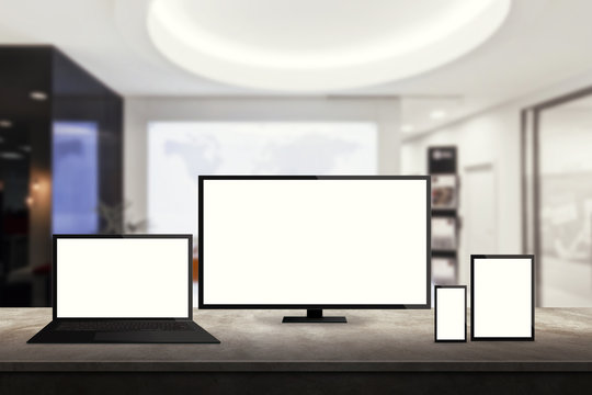 isolated responsive computer and mobile devices on desk with office background for mock up presentation
