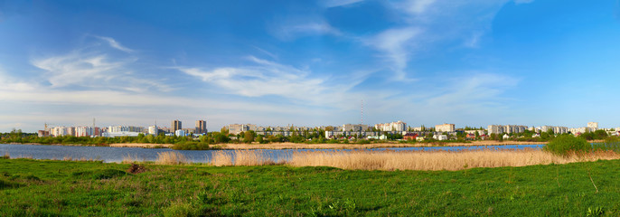 Cityscape on green grass and blue sky