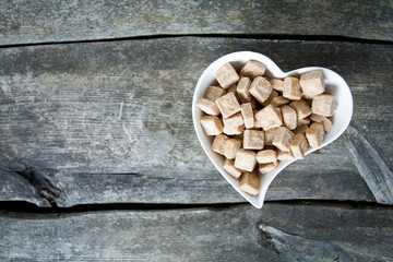 Fototapeta na wymiar brown sugar cubes in a heart-shaped bowl